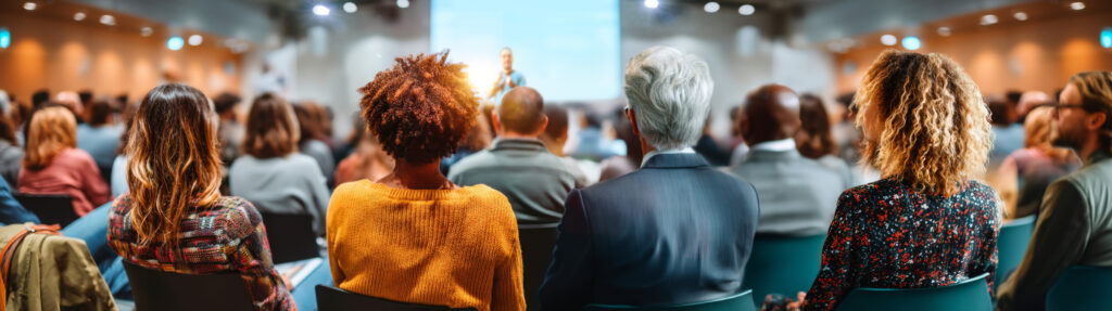 Seated audience attentively listening to speaker during indoor s